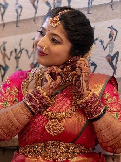 A glowing bride in her vibrant pink saree, showcasing her intricate Bridal Extravaganza mehendi. Her happy expression says it all.