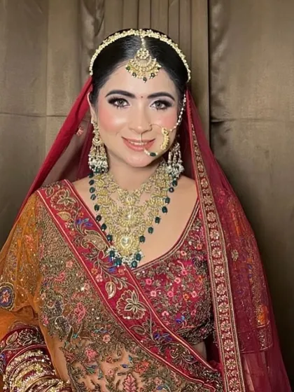 This beauty is breathtaking. A bride in a multi-toned lehenga, wearing a heavy, traditional temple jewellery set.