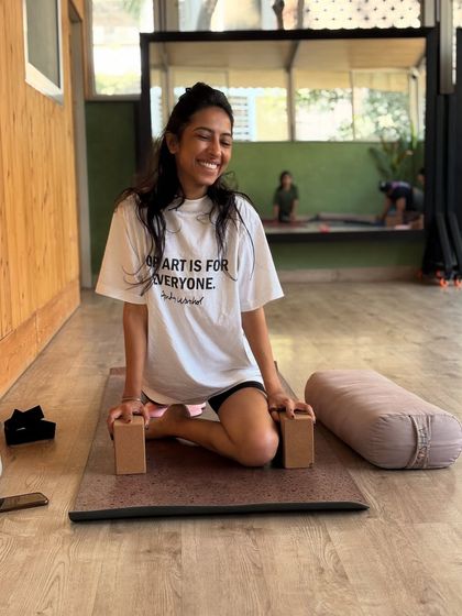 A happy smile after a good stretch. Using blocks for support in hero pose can make it more comfortable and beneficial.