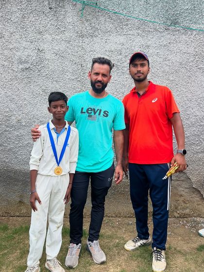 Siddharth with his Man of the Match medal, standing alongside our coaches.