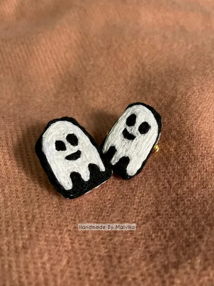 A closer look at the two friendly ghost badges. Each one is stitched by hand, so they have their own slightly different, quirky personalities. They are a simple and fun piece of wearable art.