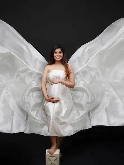 God gave wings to all mothers, they just aren't always visible. This portrait with flowing white fabric wings is a tribute to the divine power of motherhood.