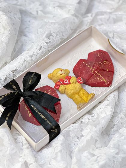This cute Valentine's hamper includes two red velvet heart-shaped cakesicles and a little teddy bear. It's a small, sweet gesture of love, packed and tied with a bow.