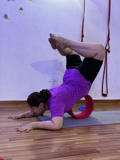 The yoga wheel is one of my favorite props for opening the heart. This forearm stand variation, supported by the wheel, is a powerful chest and shoulder opener.