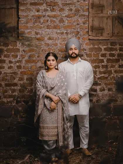 Posing against a weathered brick wall, Aman and Simran look elegant and poised in their traditional Punjabi outfits. This portrait highlights the beauty of simplicity and heritage.