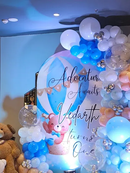 Another angle of Vedarth's first birthday decor, showing the large teddy bears and the '1' marquee light that complete the setup.