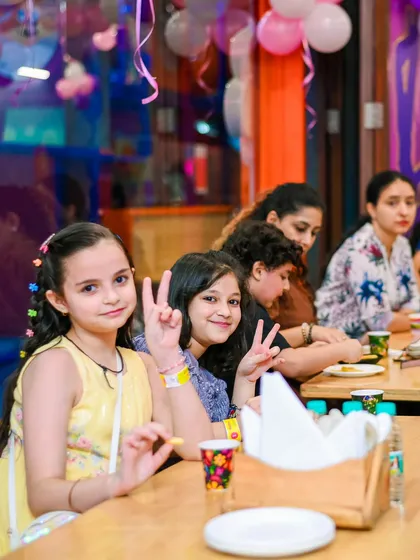 Friends posing for a photo while enjoying snacks at the cafe during a party.
