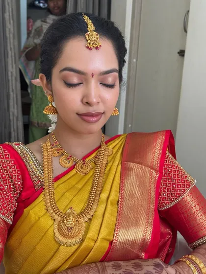 Dr. Sushmita with her eyes closed, showcasing the delicate and soft eyeshadow work. The neutral tones enhance her eyes without being overpowering, fitting the brief for a subtle and natural bridal look.