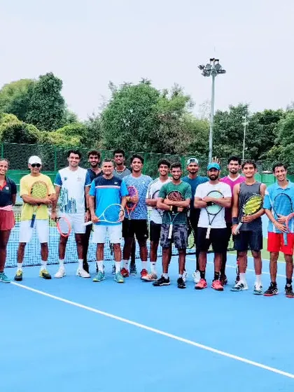 We are a team, a family. This is a glimpse of our entire group of dedicated male and female players and coaches, standing together on our blue hard court, ready for another day of rigorous training.