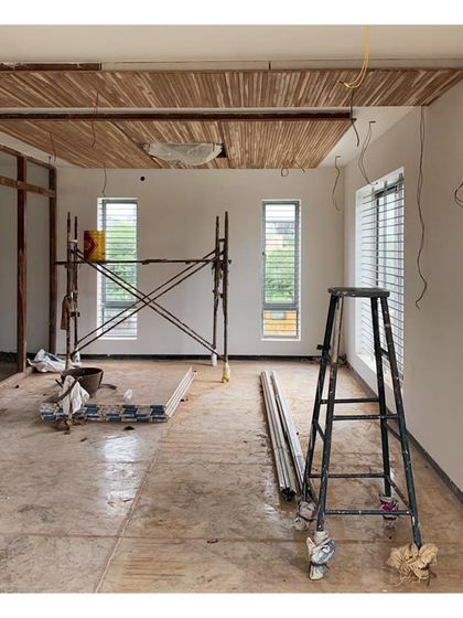 A site photo showing the installation of a bamboo false ceiling in a double-height living space.
