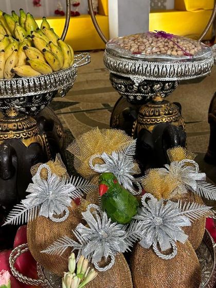 A close-up of decorated coconuts and banana offerings on elephant-themed stands.