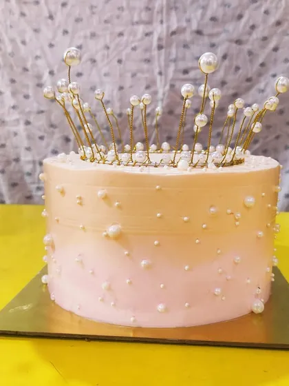 For a touch of pure elegance, I designed this pearl-themed cake. It features a soft pink ombre buttercream, scattered with edible pearls and topped with a delicate, non-edible pearl crown.