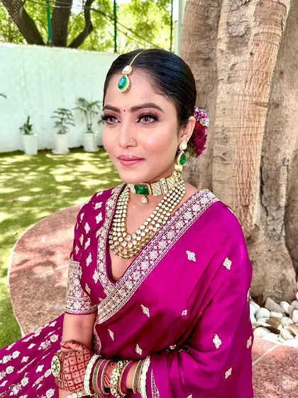 A closer look at this bride's radiant makeup. The soft eyeshadow and perfectly defined liner enhance her features, while the emerald jewelry adds a regal touch to her wedding day style.