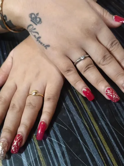 This is a powerful and glamorous nail set, perfect for a wedding reception or a big party. I used long, square-shaped extensions with a deep red polish and full-coverage gold glitter on the accent nails. The tattoo on her hand adds to the cool vibe.