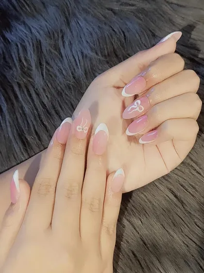 A cute and playful French manicure with delicate white bow art on the accent nails. This design combines classic elegance with a touch of fun.