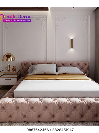A closer look at one of our custom-built beds, designed to be a statement piece. The entire frame, from the headboard to the base, is fully upholstered in a dusty pink fabric with deep button tufting. This technique adds a layer of luxurious texture and visual interest to the bedroom.