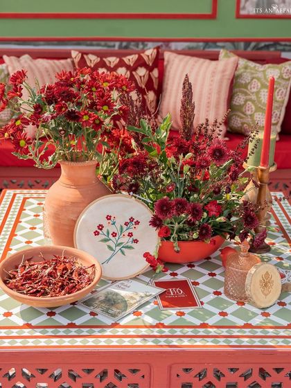 A tabletop detail featuring custom stationery, embroidered art, and bowls of spices like dried red chilies, adding a sensory element to the decor.