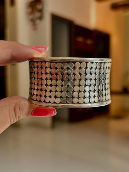 A close-up shot of the wide, textured silver cuff, highlighting its dotted pattern.