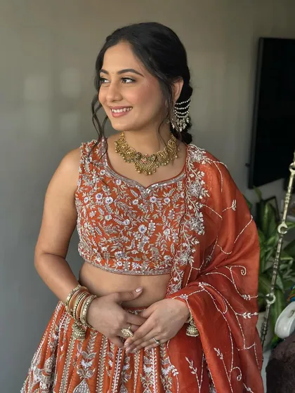 A seated portrait showing the full Garba Night ensemble. The makeup is perfectly balanced with her outfit and jewelry for a cohesive look.