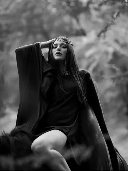A powerful pose from the same black and white series, where the model's flowing robe and confident posture create a sense of drama.