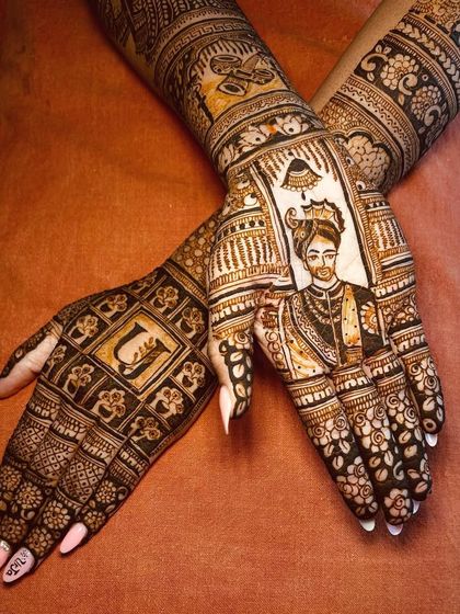 A stunning bridal mehendi featuring a portrait of the groom on one hand and his initial on the other, symbolizing their union.