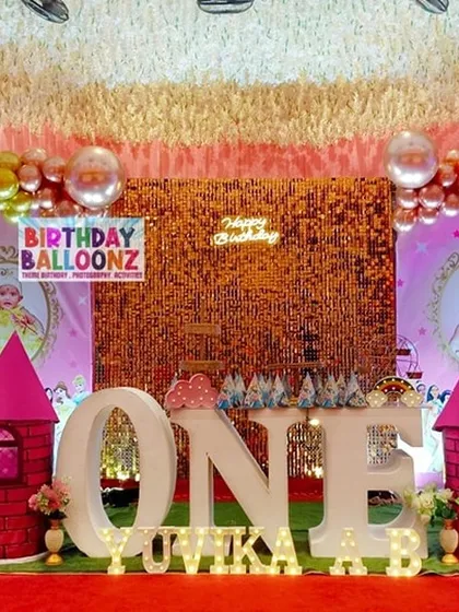 I created this grand princess castle theme for a first birthday celebration. The design features large "ONE" marquee letters, pink castle turrets, a shimmering gold backdrop, and personalized photo frames, all set on a red carpet for a truly royal feel.