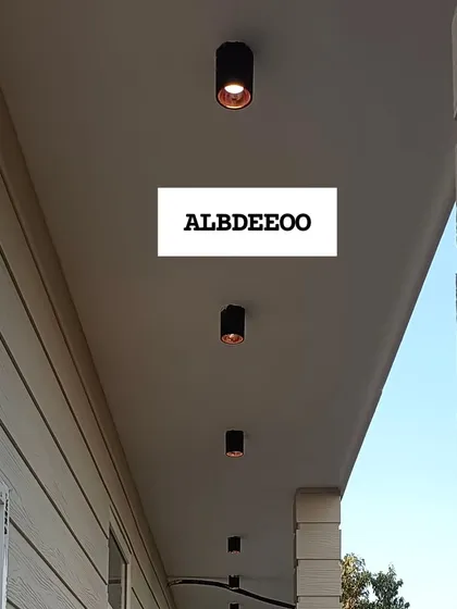 A series of detailed shots of a terrace prefab house's exterior. These images focus on the wood-textured cement plank elevation, modern ceiling lights, and high-quality VEKA window frames.