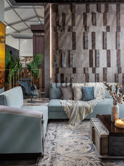 Designing the ID Booth for Quba Homes involved encapsulating their brand philosophy through colors and materials. This feature wall's interplay of textures commands attention, while the plush furnishings intertwine comfort with artistic flair.