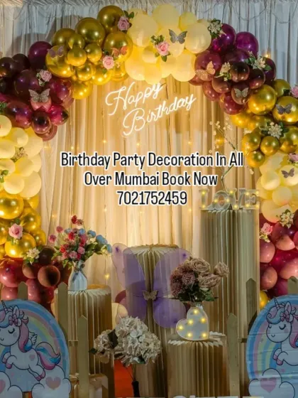 A whimsical unicorn and butterfly theme with a beautiful balloon arch in warm tones. The setup includes unicorn cutouts and a neon sign, perfect for a magical birthday.