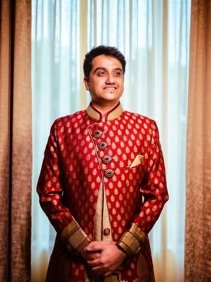A simple yet elegant indoor portrait of the groom against a soft, backlit curtain.