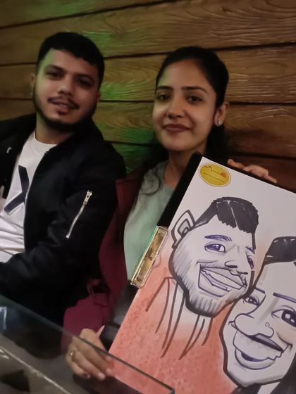 A couple posing with their caricature at the restaurant.