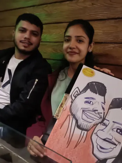 A couple posing with their caricature at the restaurant.