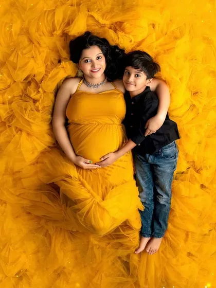 The journey to motherhood is a universe of its own. This stunning overhead shot celebrates the beauty and power of a mother-to-be, wrapped in a vibrant gown that's as full of life as she is.