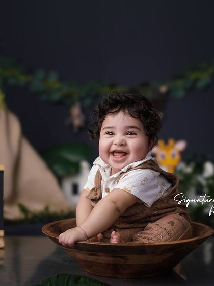 Another joyful shot from the jungle theme, with the baby laughing in a wooden bowl surrounded by safari animals.