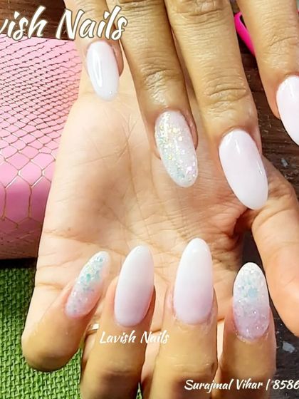 Milky white almond nails with two different styles of silver glitter accent nails.