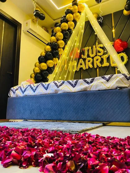 Another perspective of the black and gold first-night decor, showing the details of the rose petal arrangement on the floor.