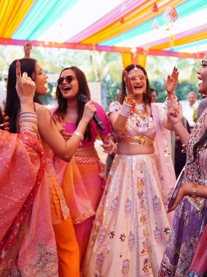 A group of friends singing and dancing with the bride at her Mehendi. These are the moments that make a wedding.