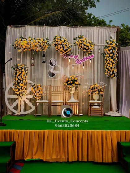 A bright and cheerful Roce ceremony stage with yellow and white florals. The large white wheel prop adds a unique, rustic touch to this outdoor setup.