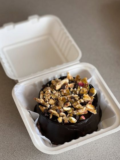 A chocolate bento cake topped with a delicious mix of pistachios and almonds for a nutty crunch.