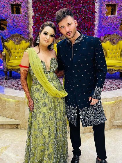 Our client posing with the bride in his custom navy Indo-Western. The intricate silver embroidery makes it a perfect outfit for a wedding guest.