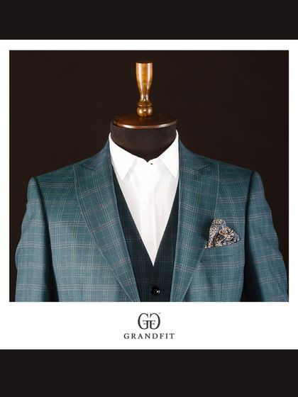 For the gentleman who embraces color, this teal plaid three-piece suit is a bold yet sophisticated choice. It is a modern power suit for creative and forward-thinking leaders.