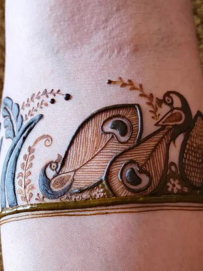 The upper portion of the bridal arm design, featuring a band of peacock motifs above the main figure. This shows how to combine different elements into one cohesive piece.