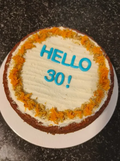 A healthy and delicious carrot and dates cake with cream cheese frosting, perfect for a 30th birthday celebration.