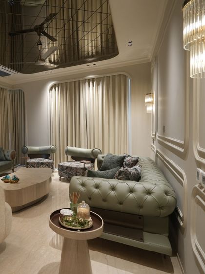 A closer look at the olive green Chesterfield sofa and floral accent chairs. The combination of tufted leatherette and patterned fabric adds depth and personality to the living room seating.