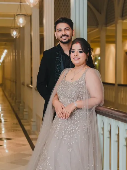 The couple posing in a grand hotel corridor, their formal attire and the elegant setting creating a sophisticated and timeless wedding portrait.