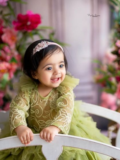 A happy, standing pose shows off this one-year-old's new skills. Milestone sessions are perfect for documenting these amazing developmental leaps.