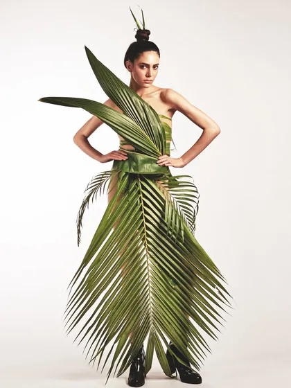 Creating a dress from nature itself. For this conceptual shoot, the makeup is kept clean and minimal to let the avant-garde leaf gown and the sculpted top-knot hairstyle take center stage.