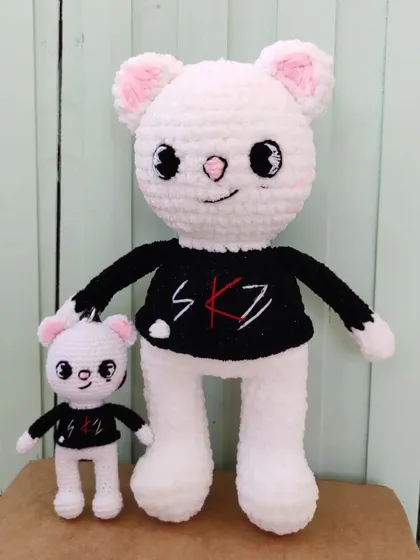 A closer look at the big and small SKZOO character dolls, showing the matching black shirts with the SKZ logo.