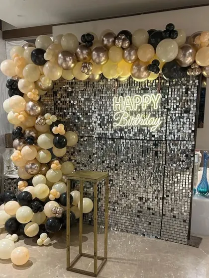 To create a softer, warmer look, I paired the silver sequin wall with a balloon arch in cream, black, and muted metallic tones. The "Happy Birthday" neon sign adds a bright focal point to the arrangement.