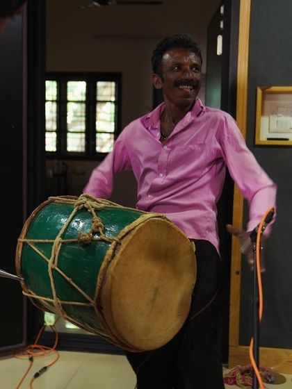 A Dollu player from Sagara, mid-performance in the studio. The energy is palpable even in a still photo, showcasing the power of these folk instruments.